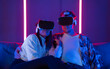 © ADDICTIVE STOCK - Diverse man and woman in VR headsets sitting on sofa