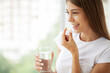 Woman Taking Pill With Cod Liver Oil Omega-3 And Holding A Glass Of Fresh Water In Morning