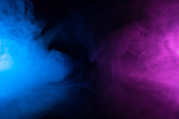 Wall Mural - clouds of smoke in blue and purple neon light swirling on black table background with reflection