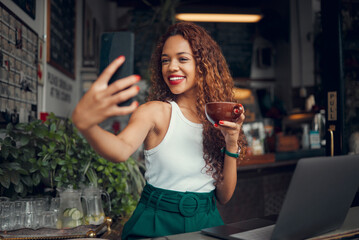 Wall Mural - Phone selfie, laptop and black woman with coffee, remote worker or freelancer drinking espresso in cafe. Tea, photo and business woman from Brazil with 5g mobile for happy memory or social media post