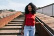 © ADDICTIVE STOCK - Cheerful ethnic woman walking on wooden stairs