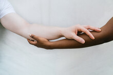 Crop multiracial couple holding hands together