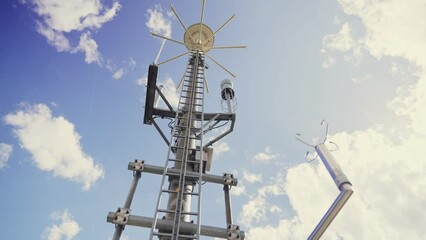 weather and communication antenna under blue sky - camera pans slowly low angle. tall tower with var
