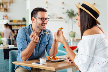 Happy loving couple enjoying breakfast in a coffee shop