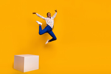 Wall Mural - Full length body size view of attractive cheery girl jumping from stage stretching twine isolated over bright yellow color background