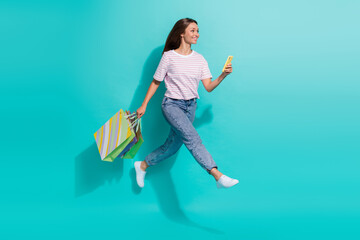 Canvas Print - Full size photo of positive cheerful woman flying jumping hold smartphone shopping bags look empty space isolated on teal color background