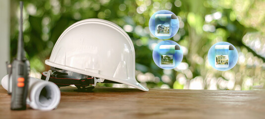 safety helmet, plastic, white, paper roll blueprints and radios on a wooden table