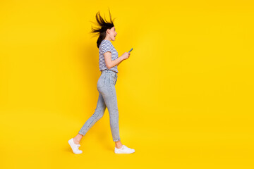 Poster - Full size profile side photo of funky satisfied impressed lady arm hold telephone device go empty space isolated on yellow color background