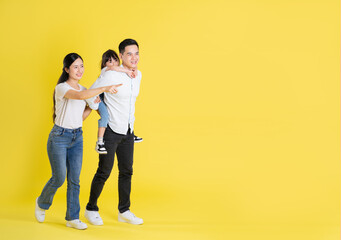 Wall Mural - happy asian family image, isolated on yellow background