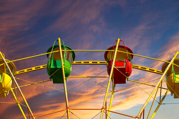 Attraction (carousel) ferris wheel against the background of a romantic evening sky