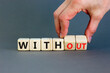 © Dzmitry - Without or with symbol. Concept words Without and With on wooden cubes. Beautiful grey table grey background. Businessman hand. Business without or with concept. Copy space.