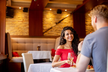 Wall Mural - Young couple having lunch with white wine in the restaurant