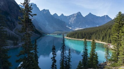 Wall Mural - Moraine lake beautiful landscape in summer sunny day morning. Shadow moves on turquoise blue water with reflection. Canadian Rockies. Banff National Park. Alberta, Canada. 4K Time-Lapse Zoom Out.