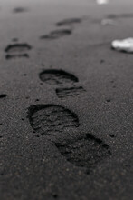 Footsteps in black sand