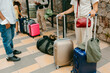 © Jimena Roquero/Stocksy - Unrecognizable group of people waiting with luggages on the street