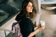 Young Woman With Coffee On The Go And Donut