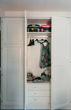 Open Closet With Clothes And Suitcases In Hotel Room