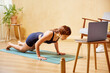 © ALTO IMAGES/Stocksy - Sportswoman doing knee plank near laptop