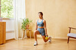 © ALTO IMAGES/Stocksy - Sportswoman lunging with kettlebells at home