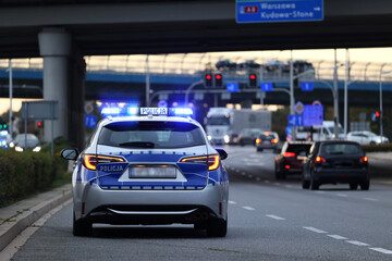 Wall Mural - Polscy policjanci i ich pojazdy podczas wieczornej służby w mieście.