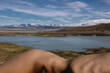 © Anastasia Mihaylova (Shpara)/Stocksy - Nude woman lying in front of the lake and snowy mountains in Iceland