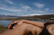© Anastasia Mihaylova (Shpara)/Stocksy - Naked woman lying in front of the river and snowy mountains in Iceland
