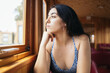 © Pedro Merino/Stocksy - Thoughtful young woman traveling by train