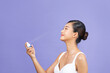 © Marc Tran/Stocksy - Beautiful woman applying spray water treatment on face