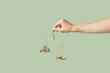 © Yaroslav Danylchenko/Stocksy - Coins weighed on scales in woman's hand.