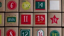 Beautiful Advent Calendar Craft Boxes With Numbers On The Table, Flat Lay Close-up In Slow Motion And Tracking To The Right.