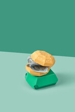 Money-stuffed Paper Burger On Green Background.