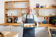 © ALTO IMAGES/Stocksy - Senior man with baked food in pan