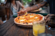 © Jovo Jovanovic/Stocksy - Pizza for dinner at a gathering with friends