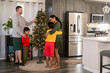 © ByLorena/Stocksy - Diverse Family putting Christmas tree together
