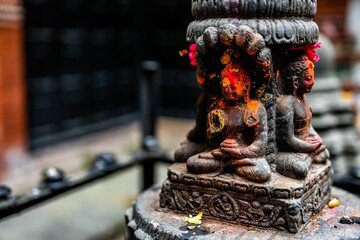 Sticker - Black Buddha idol statue with red orange yellow colored powder in Durbar Square, Nepal