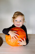 © Sergey Narevskih/Stocksy - Little child hugging pumpkin