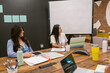 © ByLorena/Stocksy - Female mixed coworkers in conference room