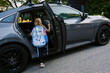 © Serena Burroughs/Stocksy - Little girl getting ready to leave for school by car