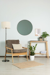 Wall Mural - Stylish living room interior with wooden furniture, houseplants and round mirror on white wall