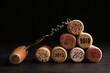 Corkscrew and wine corks with different dates on slate table, closeup