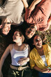 © Pedro Merino/Stocksy - Aerial view of four friends lying on the grass