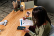 © Manu Prats/Stocksy - Hispanic woman calculating expenses at home