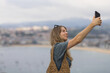 © Javier Pardina/Stocksy - Young woman photographing city of San Sebastian, Spain.
