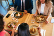 © BONNINSTUDIO/Stocksy - Diverse colleagues having lunch together