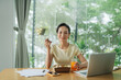 © Marc Tran/Stocksy - Young asian woman ecommerce business worker eating salad at office
