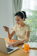 © Marc Tran/Stocksy - Busy young business woman eating a healthy lunch while working