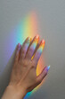 © Malin G/Stocksy - A hand with a rainbow reflection