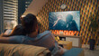 © Framestock - Couple on sofa in living room, watching action movie on TV or criminal blockbuster on streaming service, talking and discussing acting, resting at home on weekend. Home theater in modern apartment.