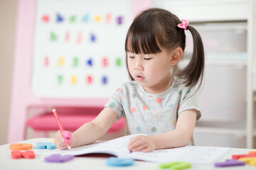 Wall Mural - young girl practice writing letters for homeschooling