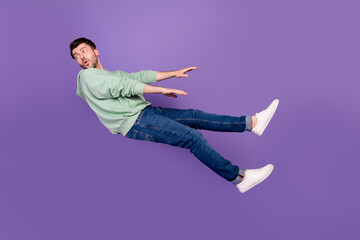 Poster - Full body photo of attractive young man wind blow away look back dressed stylish khaki garment isolated on purple color background